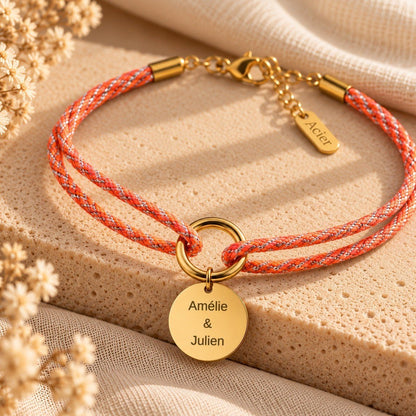 Bracelet cordon tressé orange et médaille dorée gravée de deux prénoms pour un couple